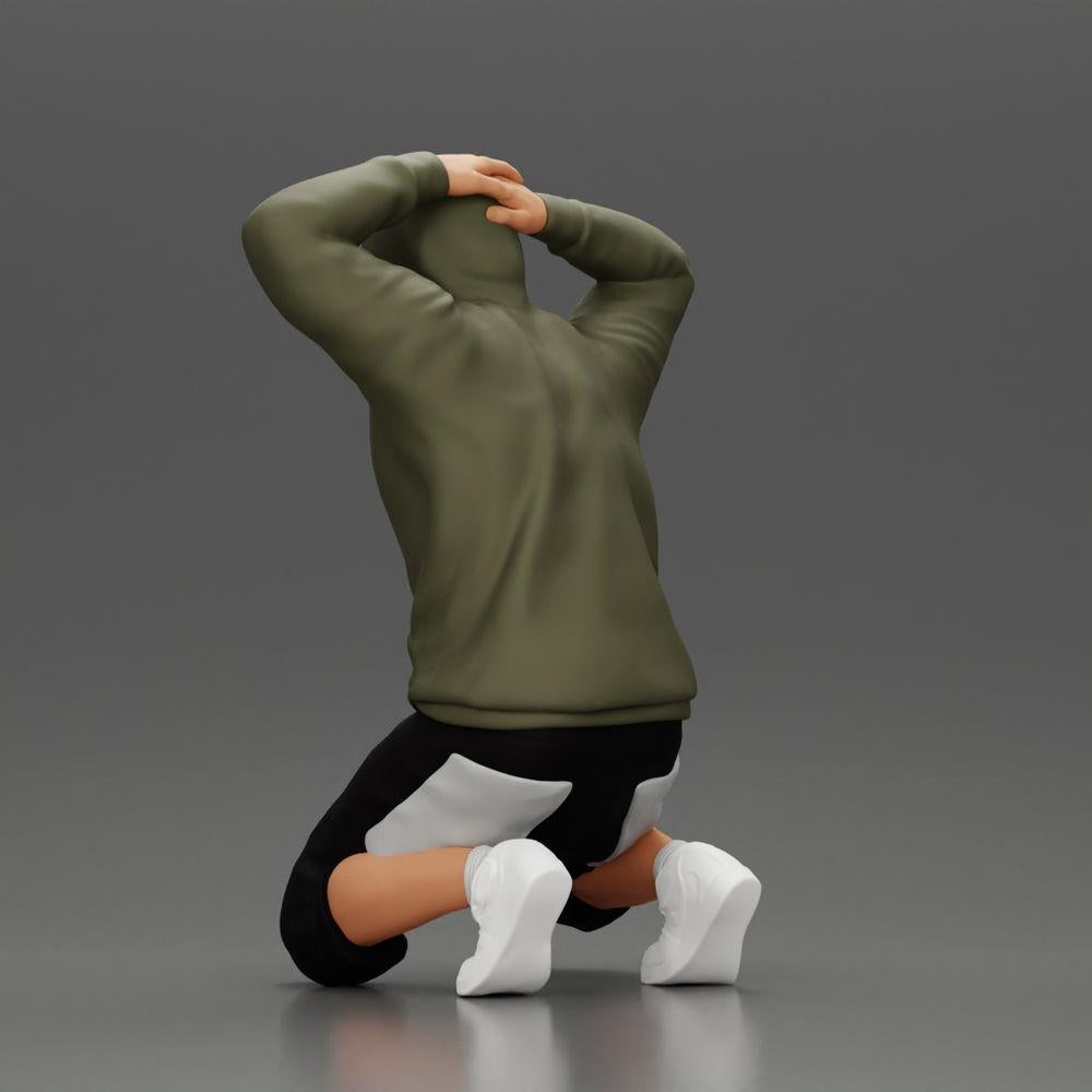 Modello diorama foto prodotto 3: Uomo inginocchiato con felpa con cappuccio, mani dietro la testa - Miniatura diorama (Rif. Nr. A70)